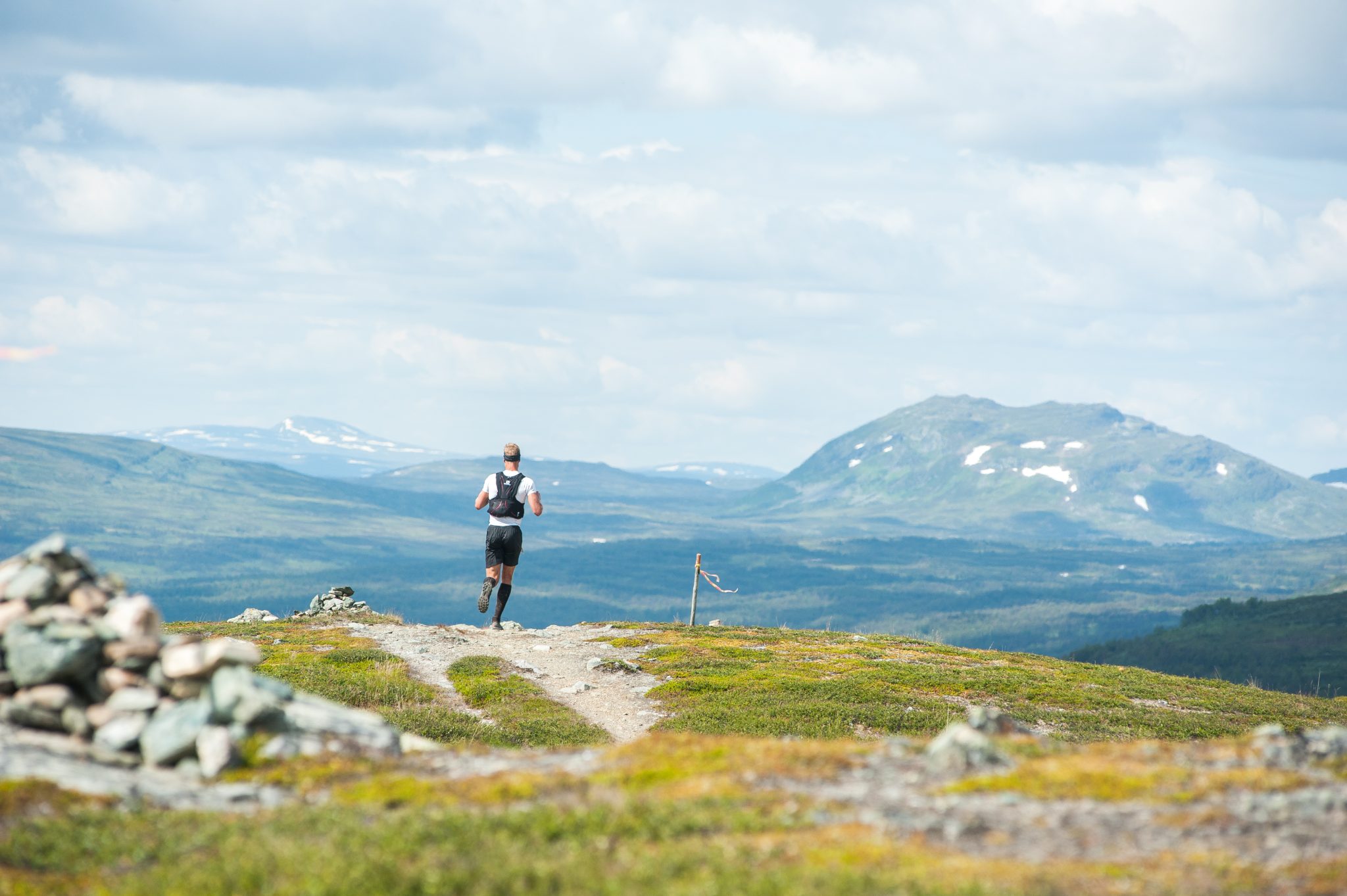 Ramundberget Trail Löpare på väg över fjället med fjälltoppar i bakgrunden